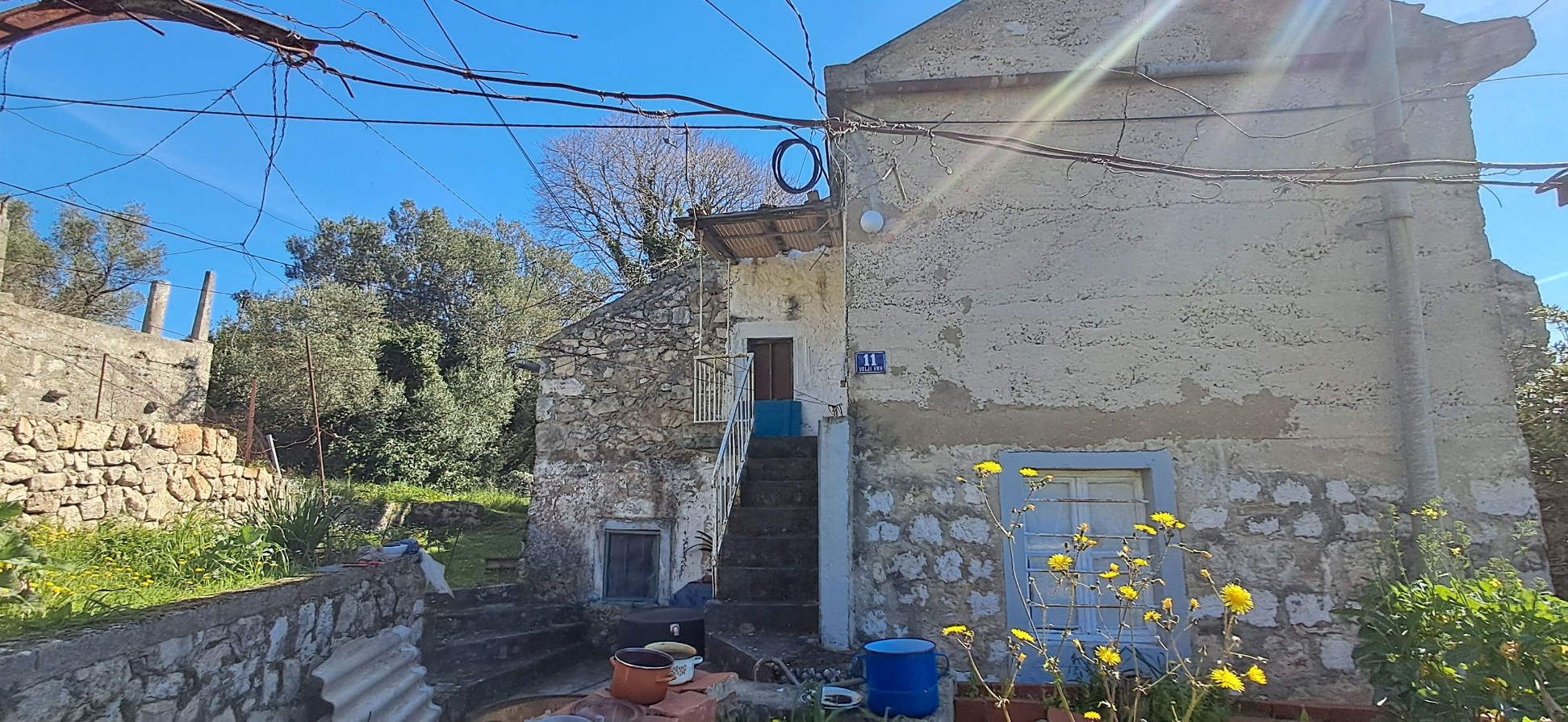 Bočni pogled na kuću okruženu zelenilom na Šipanu